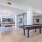 The gaming room, furnished with a hockey table, table tennis, seating area with on wall flat screen tv, and vinyl flooring
