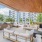 The poolside lounge area fitted with outdoor bbq grills, lounge seating, and high ceiling
