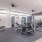 The fitness center fitted with several fitness machines, padded flooring, and high ceiling