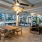 Outdoor terrace with patio seating, brick flooring, & high ceiling